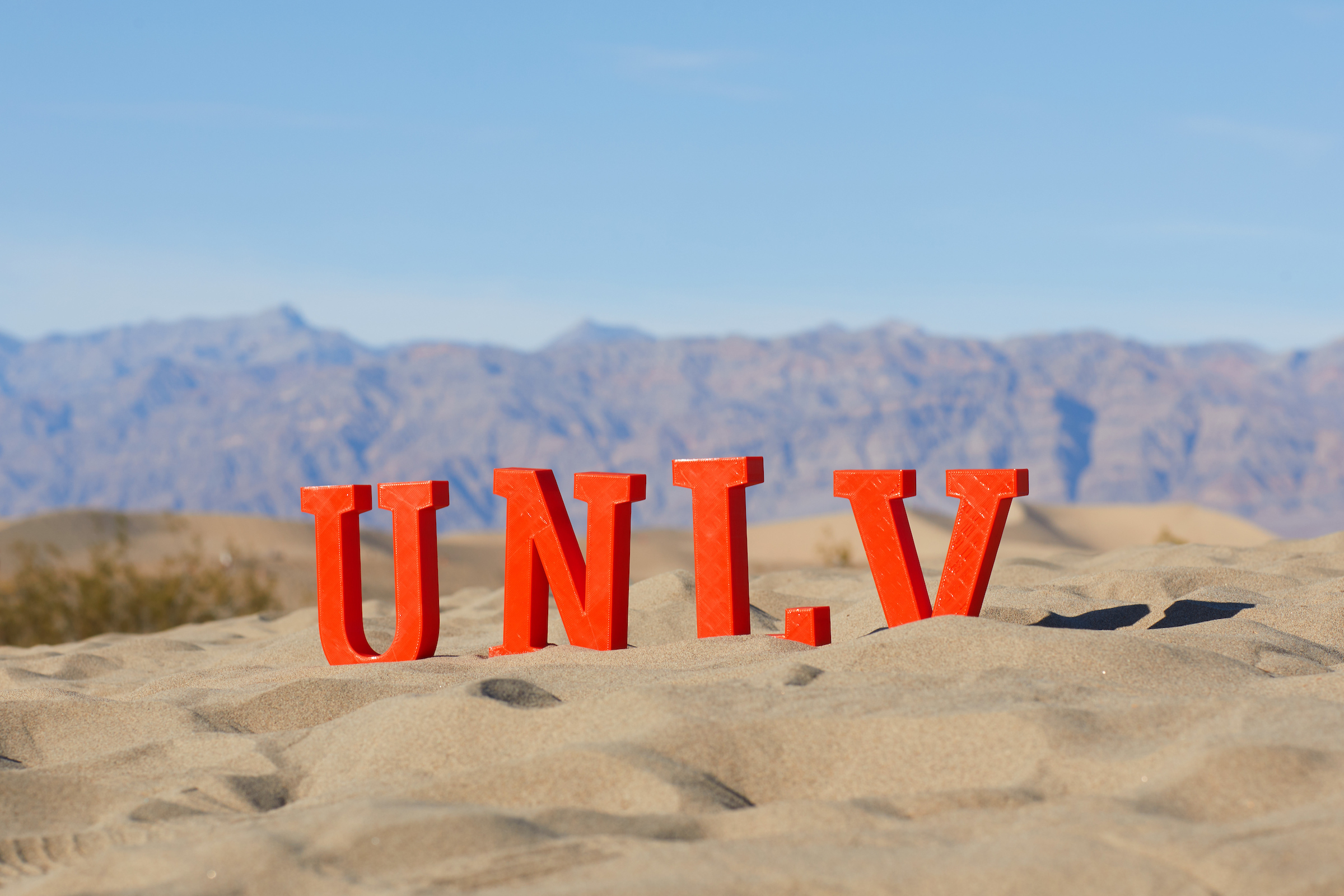 UNLV letters on sand with desert background